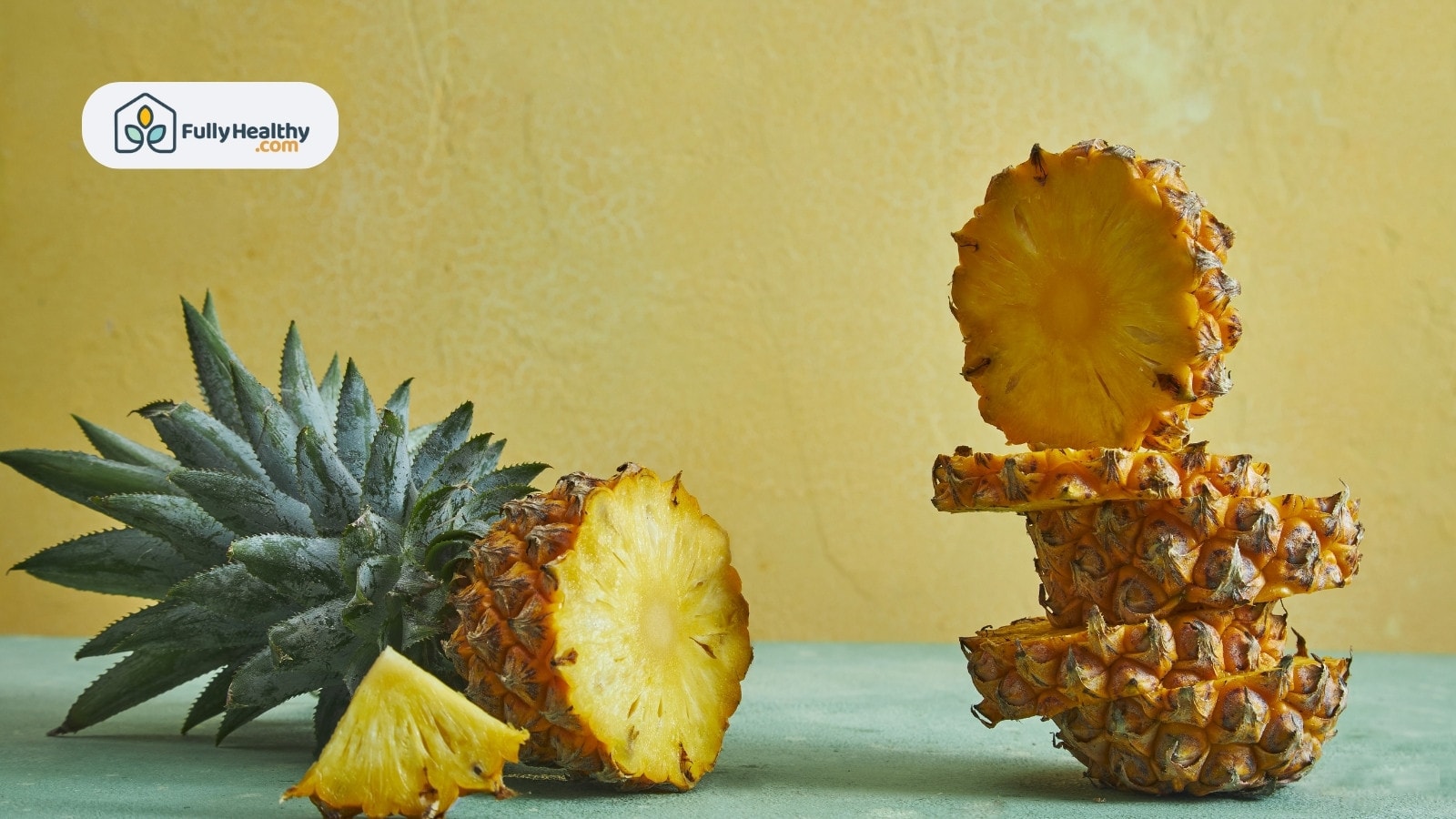 Whole pineapple and stacked slices against yellow textured wall