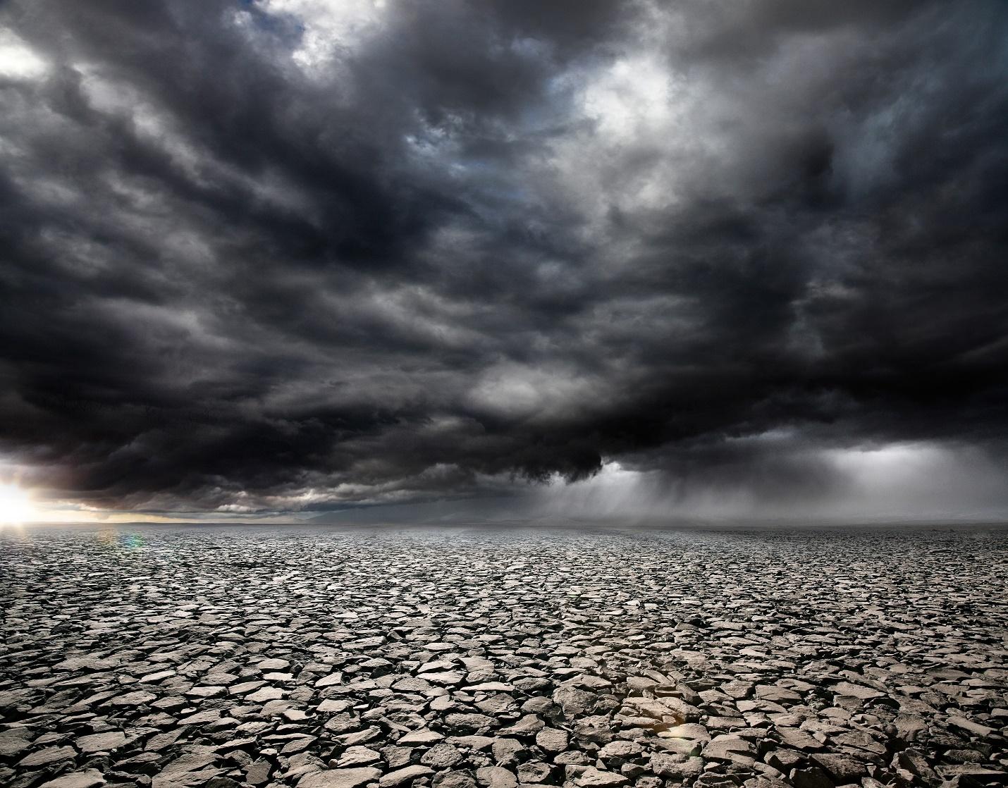 Black clouds on the sky with barren land on ground