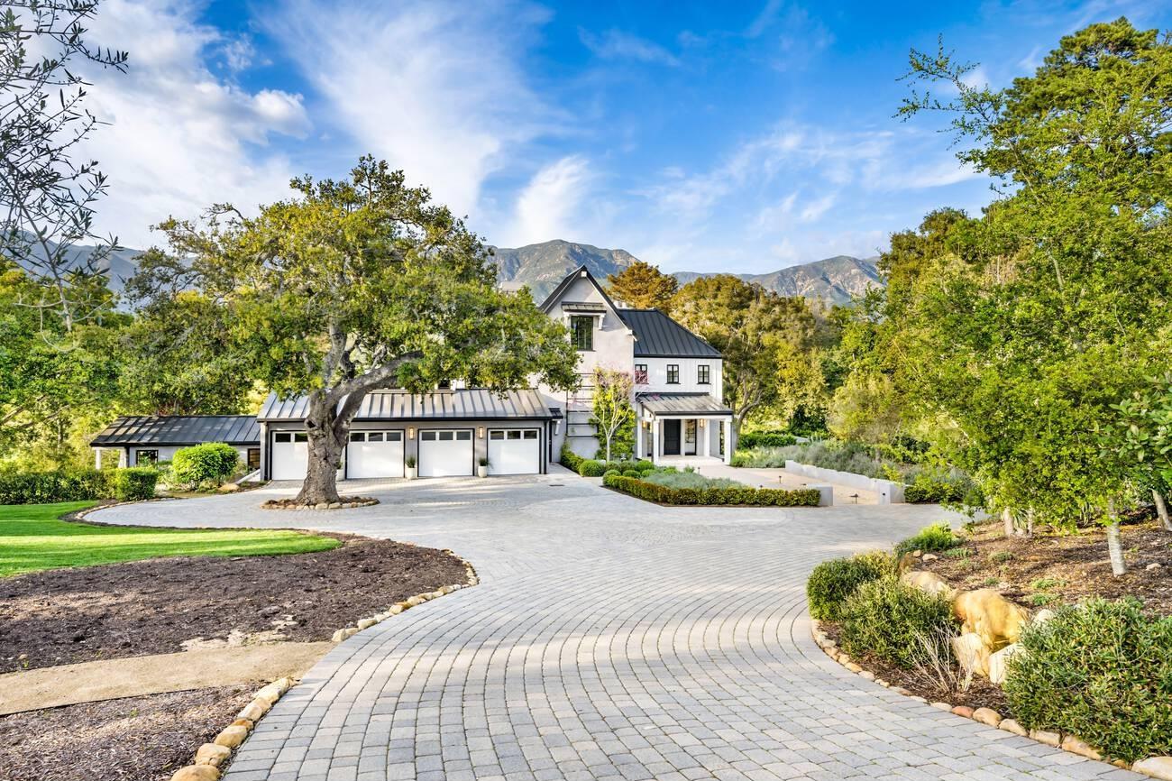 A large house with a driveway and trees

Description automatically generated