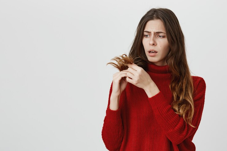 Upset girl looking at her split ends