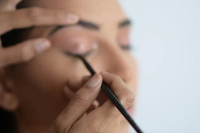 rofessional makeup artist applying cosmetics to a client in a modern salon setting