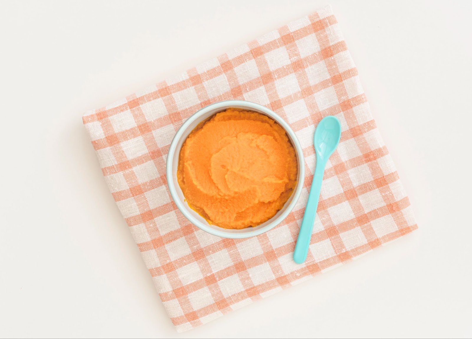 A bowl with carrot puree and a spoon