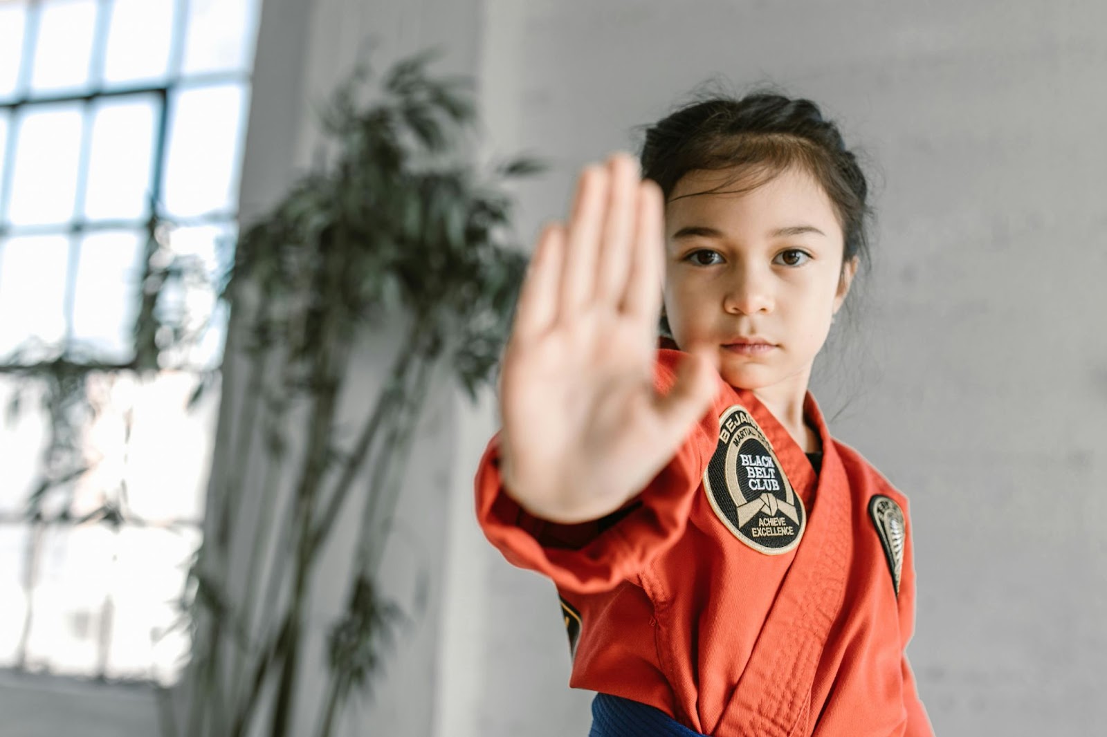 A young martial arts student with her right hand extended forward in a pose