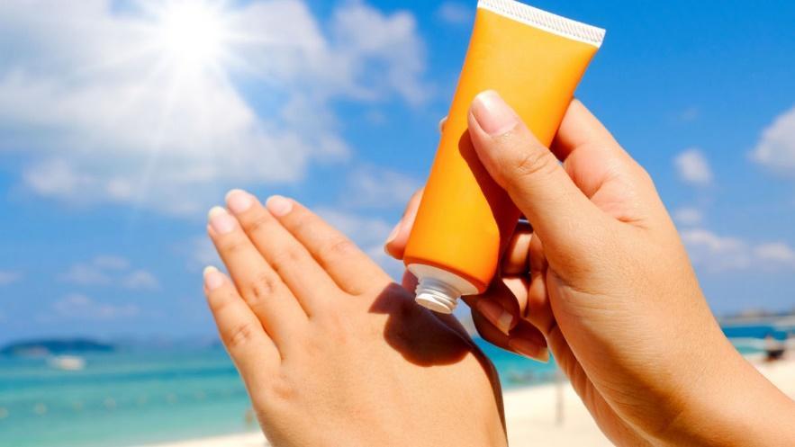 A person applying sunscreen on their hands

Description automatically generated