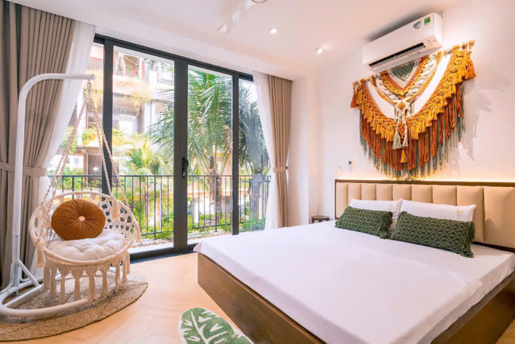 Phòng ngủ chính tại Jenna Villa với giường đôi rộng rãi, nội thất gỗ óc chó sang trọng và ban công view đẹp