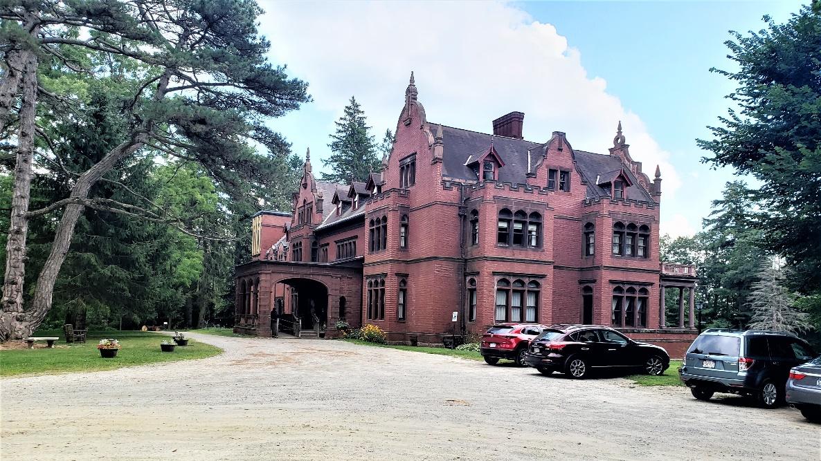 A large brick building with cars parked in front of it

Description automatically generated