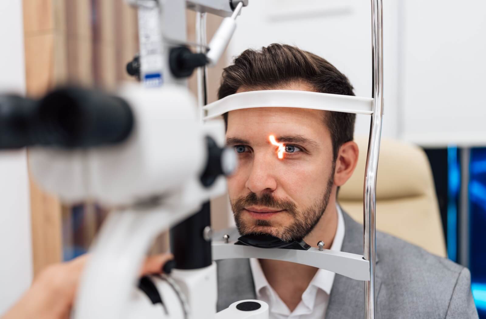 A patient undergoes a slit-lamp eye exam from an optometrist.