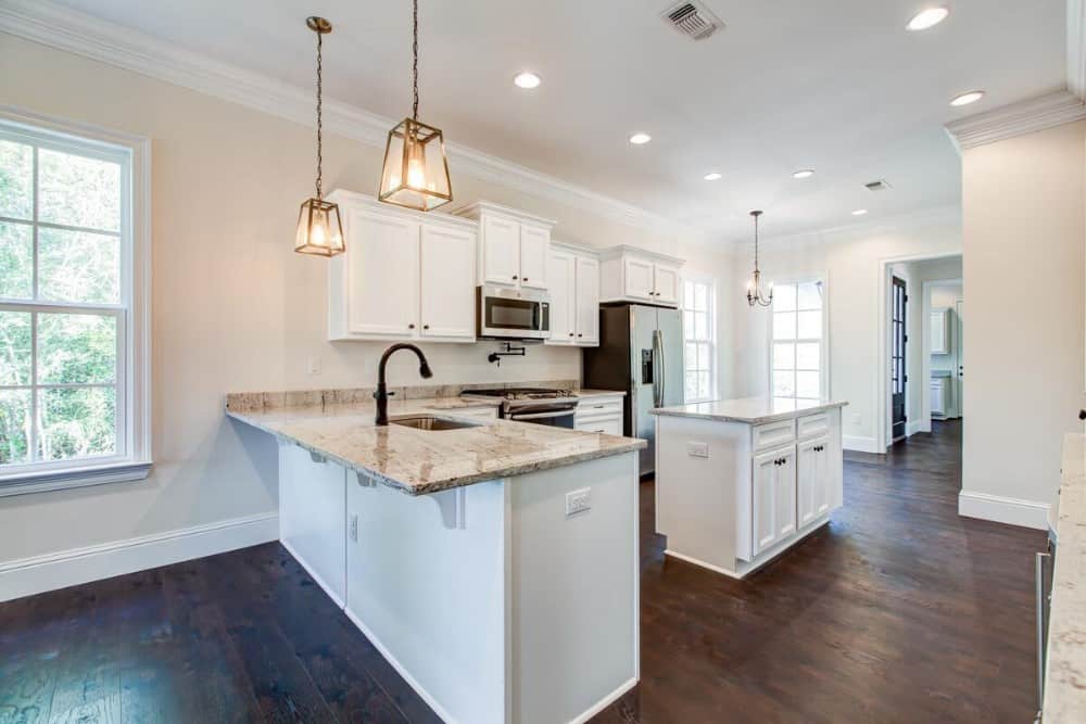 Warm glass pendants and recessed ceiling lights illuminate the kitchen.