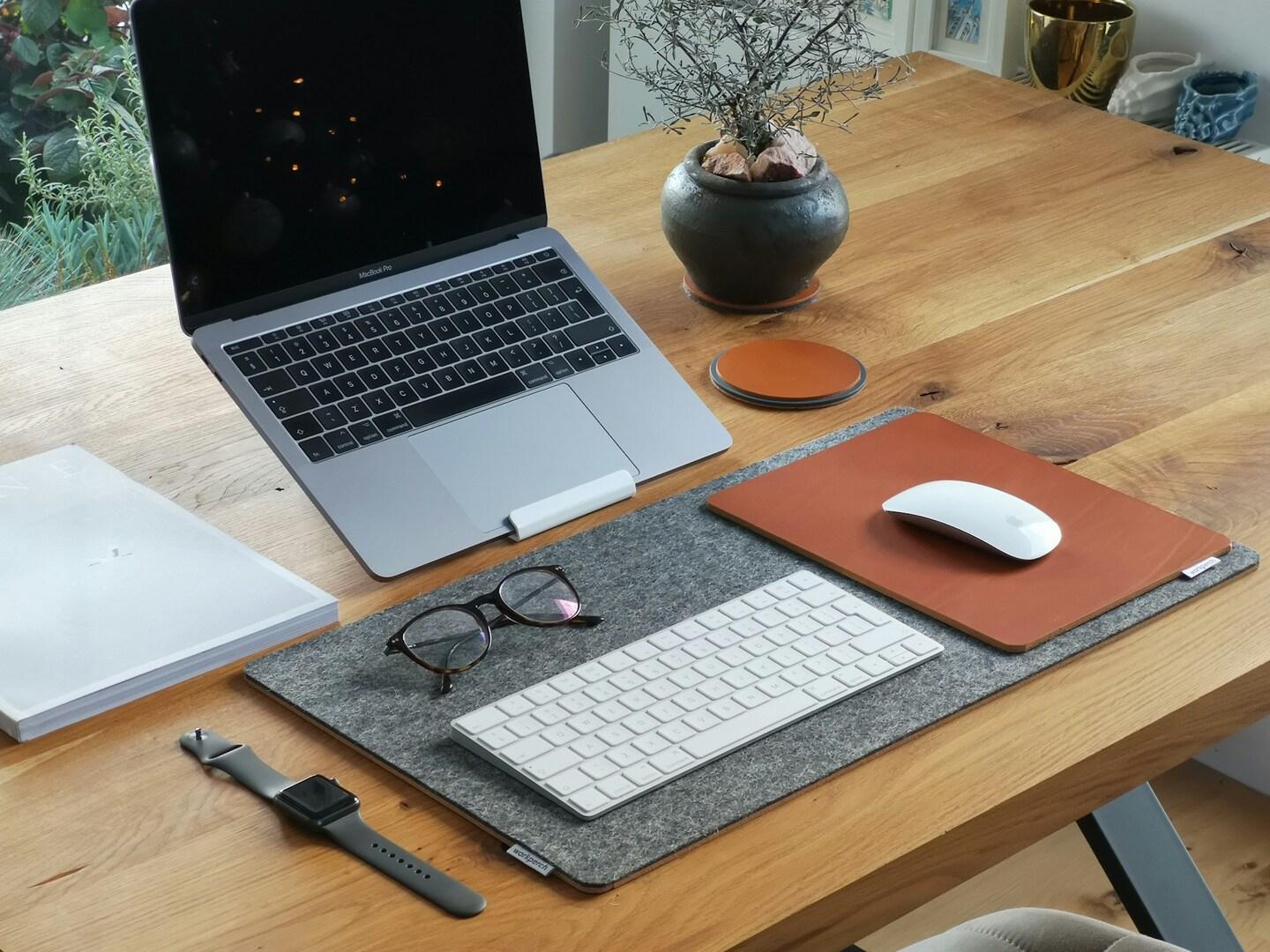 Desk essentials, including a laptop stand, wireless mouse, and keyboard.