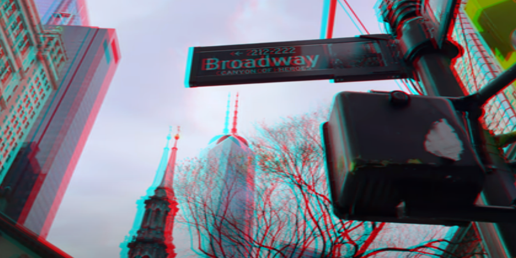 A still from an Apple Spatial Video that shows a city scene with a Broadway sign, a utility pole holding it, and buildings around it