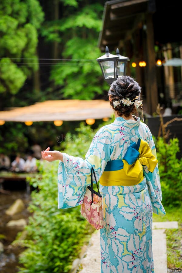 Vista posterior de mujeres vestidas con el tradicional kimono de verano japonés yukata caminando por un camino natural en Kioto, mostrando movimiento y oportunidades para tomar fotografías al aire libre.