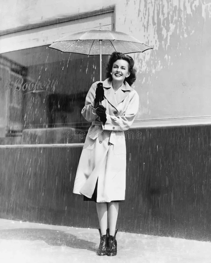 Rain photoshoot featuring a lady with umbrella, smiling joyfully.