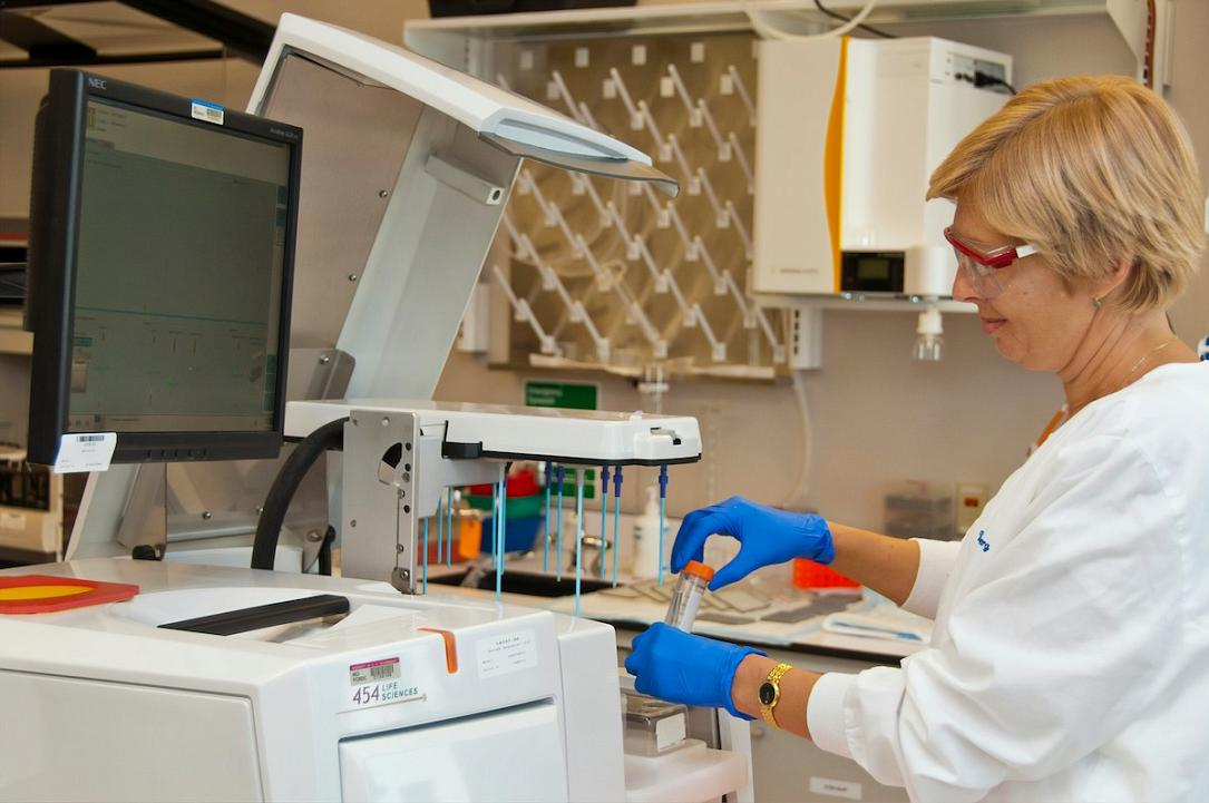 female-scientist-in-lab-coat-and-gloves-operating-genetic-sequencing-machine-in-modern-laboratory-what-big-pharma-wont-say-vesugen-for-aging-is-changing-the-game-tony-huge