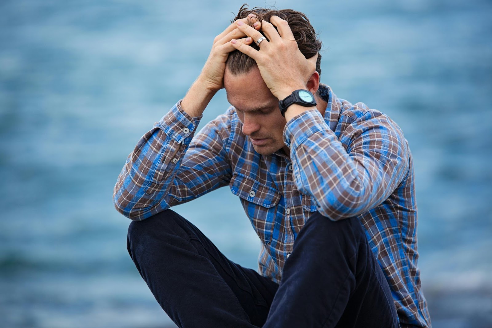 A stressed man holding his head