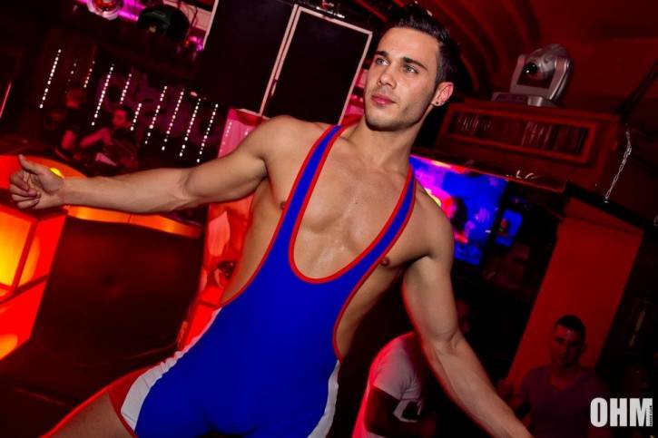 gay male twink gogo dancing in gay bar in blue and white wrestling singlet 