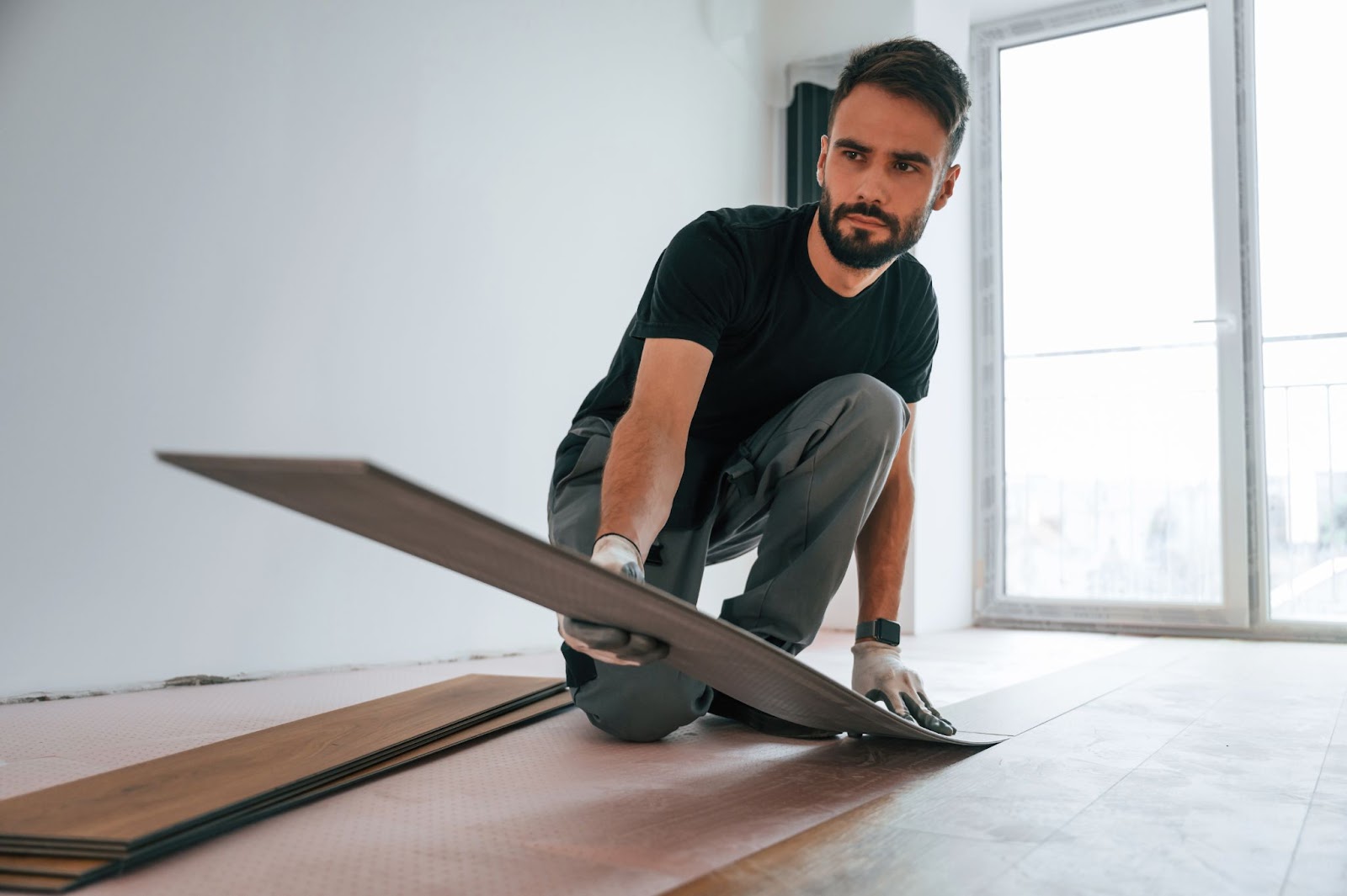 Man holding a wooden floor plank. 