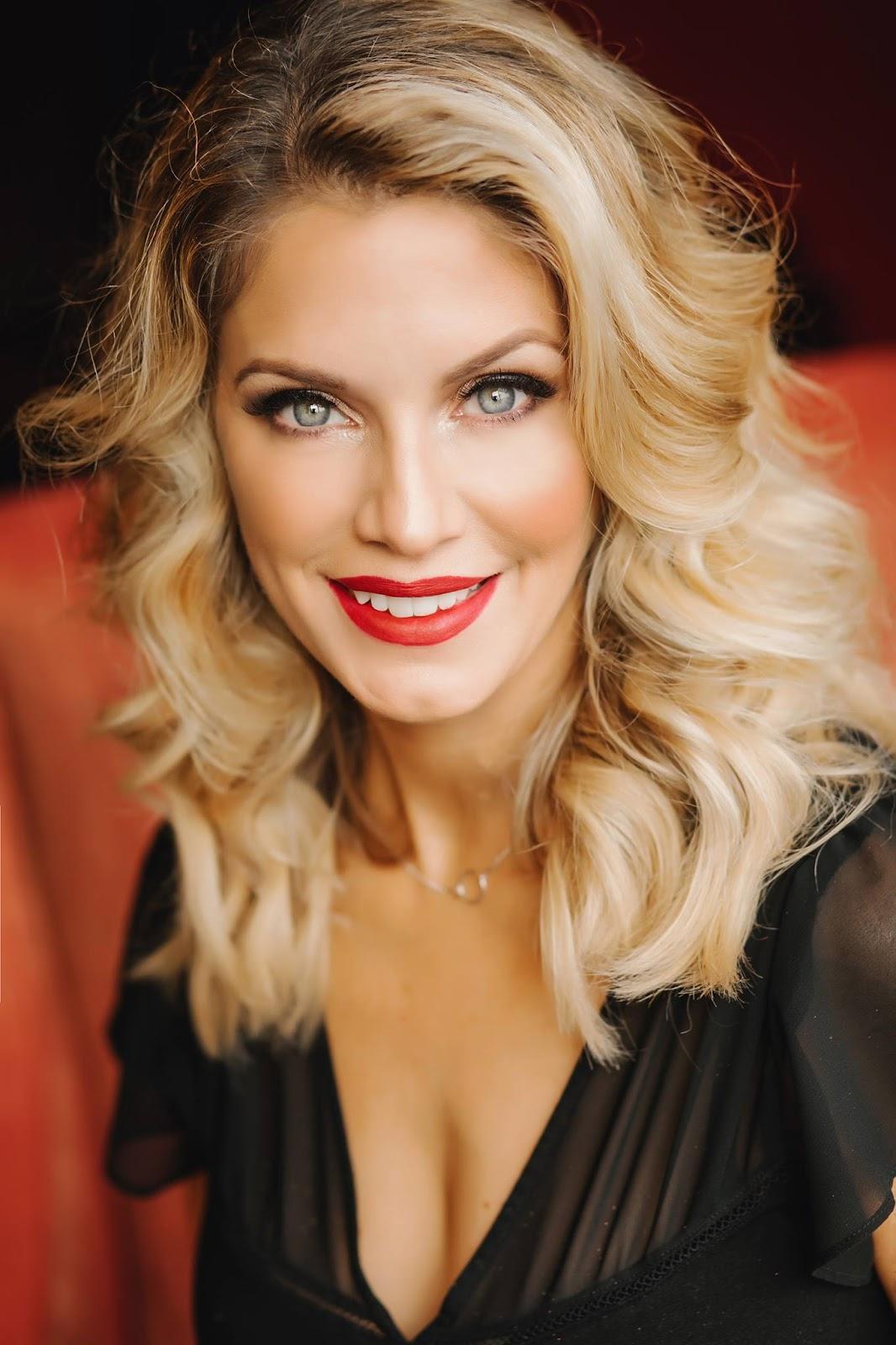 A person with blonde hair and red lipstick smiling

Description automatically generated