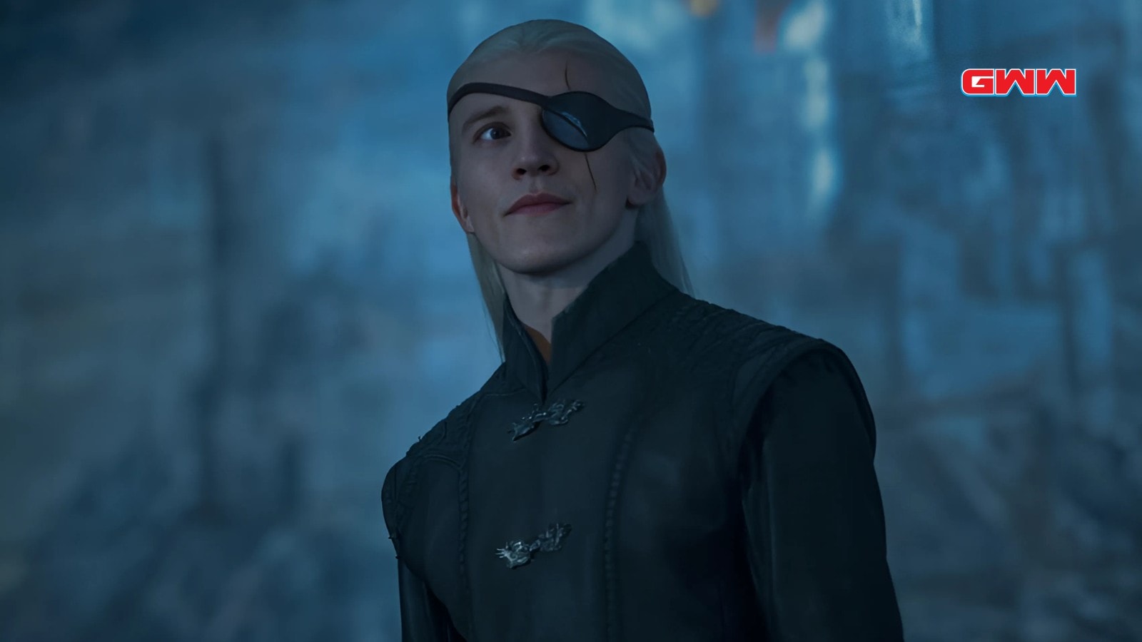Ewan Mitchell as Aemond Targaryen smirking under moonlight with eyepatch