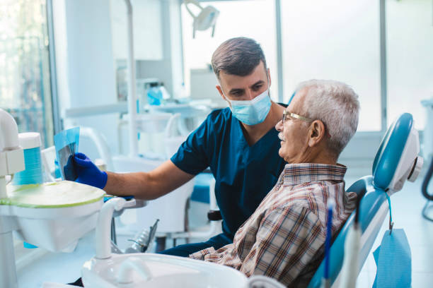 An old man getting a dental checkup by a dentist at Ridge Oral's dental solutions