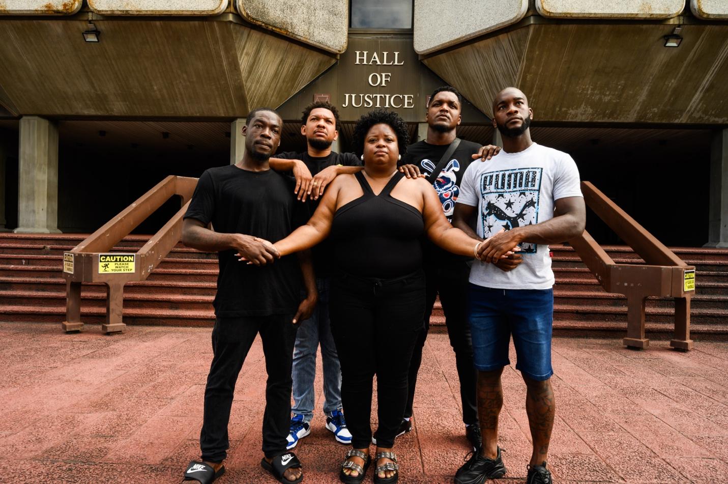 A group of people standing together in front of a building Description automatically generated