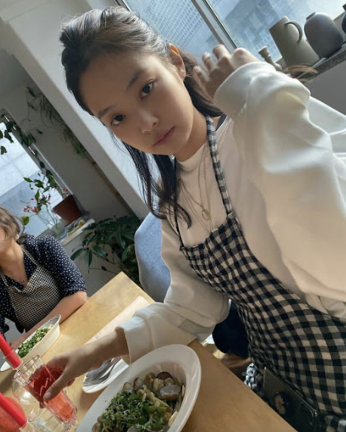 A picture of jennie on a white hoodie sitting in front of a table 