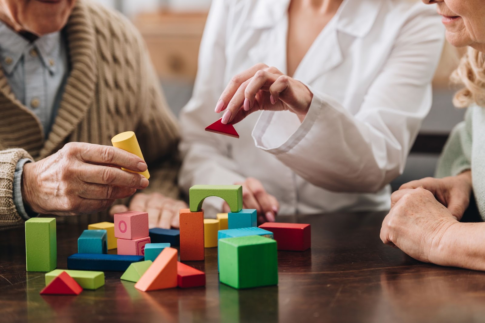 a group of seniors are moving puzzles around from a memory game to help with the onset of dementia.