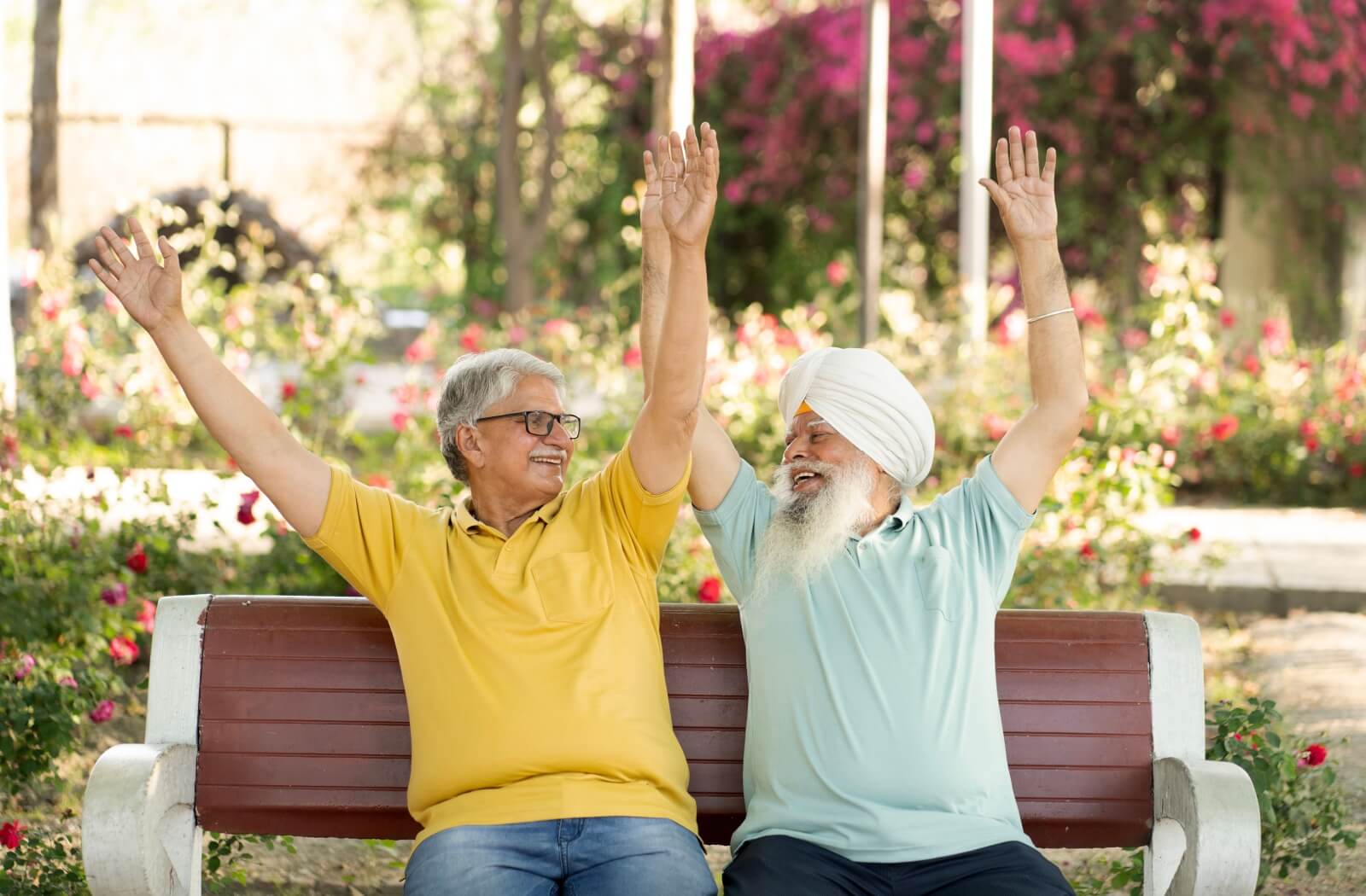 A couple of senior friends laughing together as they enjoy an outdoor communal area in their senior living community.