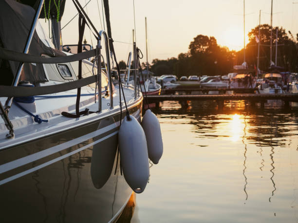 A boat docked at sunset with white fenders