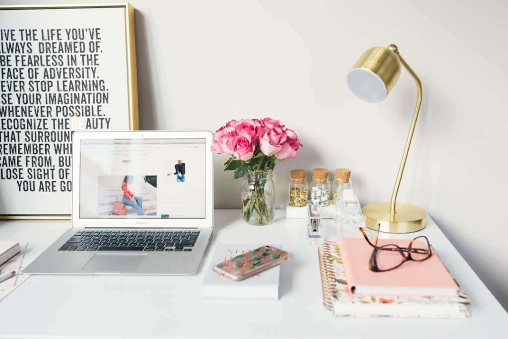 MacBook Air beside gold-colored study lamp and spiral books by Arnel Hasanovic