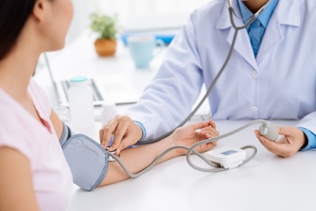 doctor measuring blood pressure of a young Asian woman using the inflatable cuff to detect the risk of cardiovascular issues early