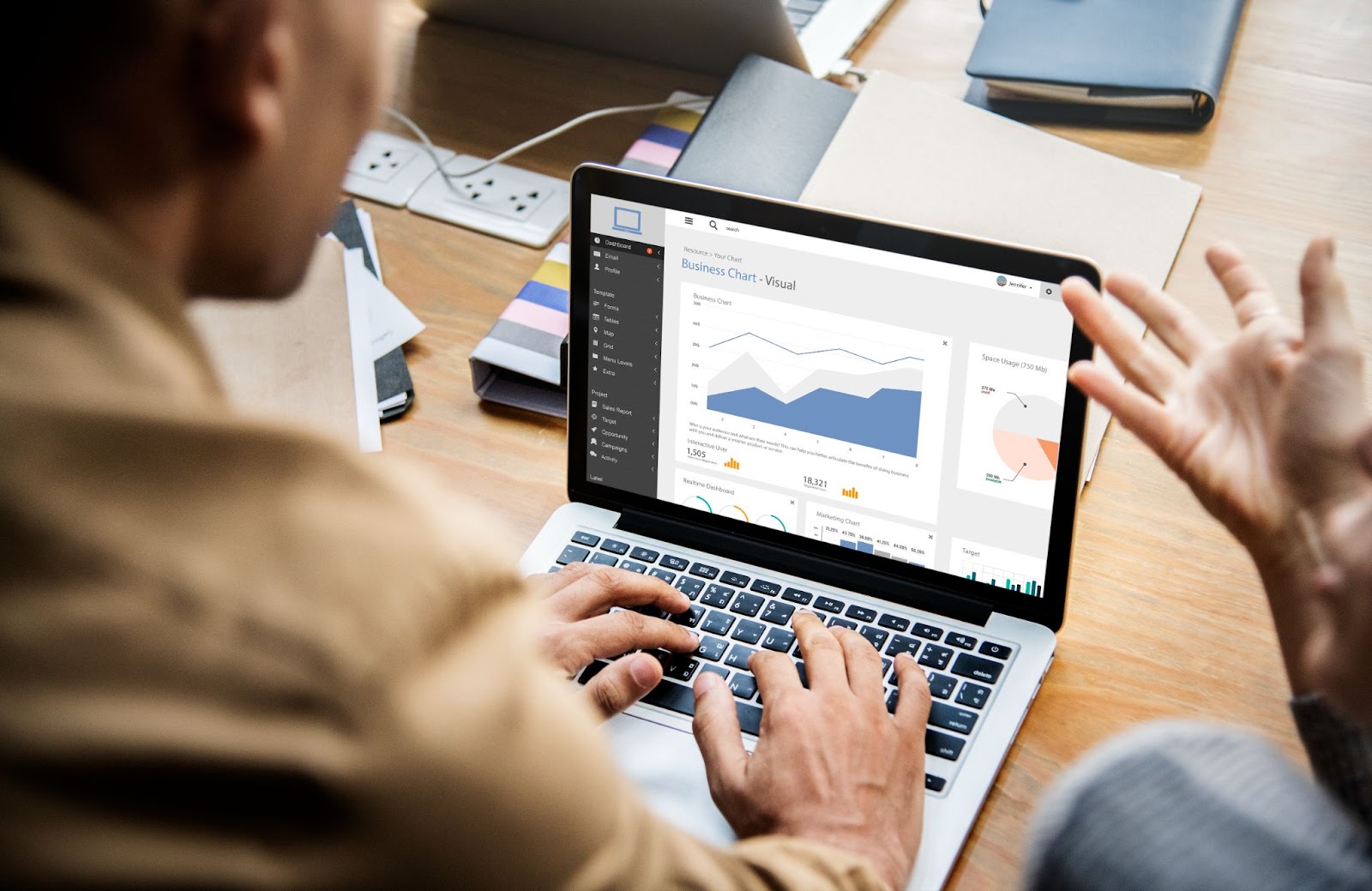 Una persona con una notebook en una mesa de trabajo analizando métricas a través de LinkedIn Analytics.
