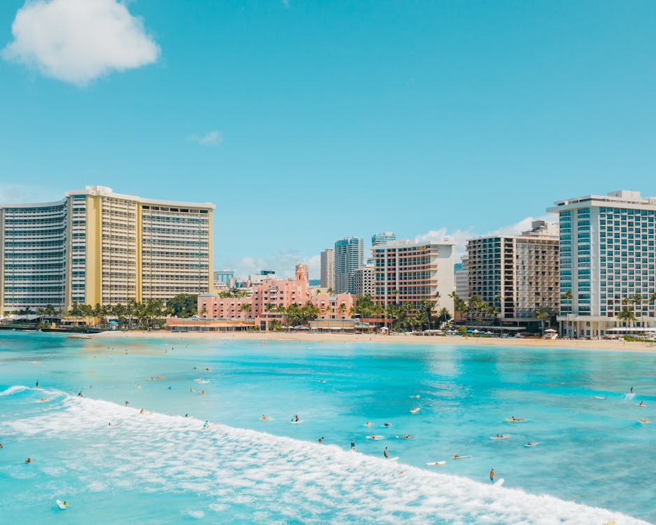 Free Surfers and Buildings at the Waikiki Beach Stock Photo