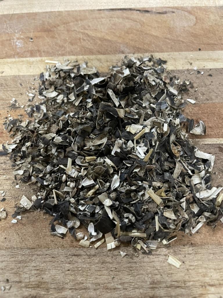 A pile of black and white shavings on a wooden surface

AI-generated content may be incorrect.