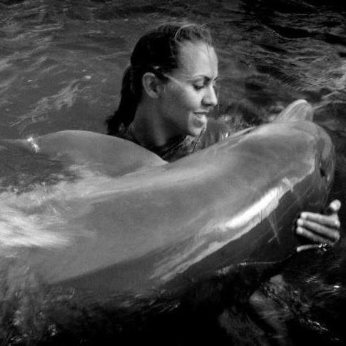 rachel in the sea with a dolphin rather than a dog