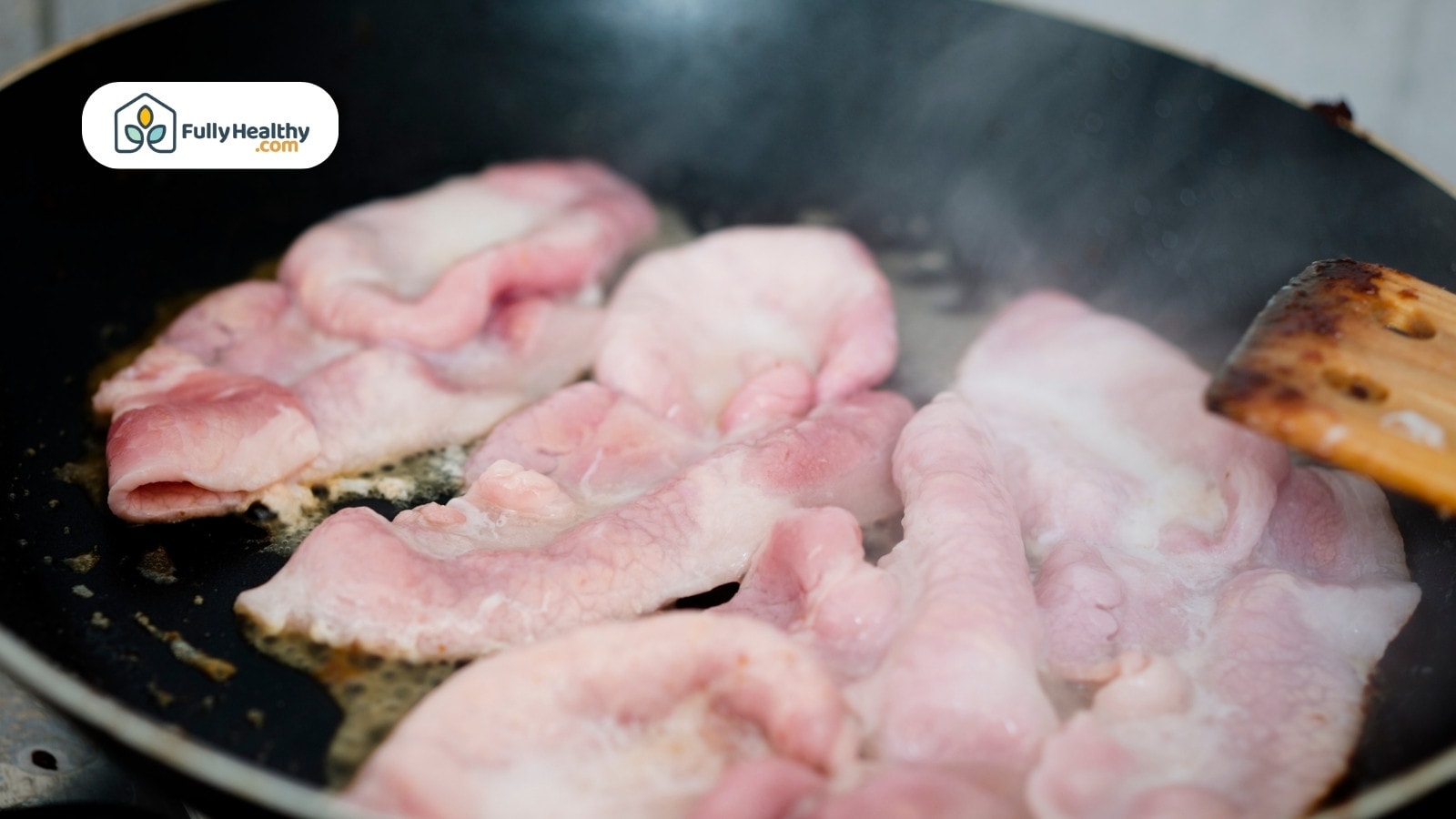 Raw bacon strips sizzling in frying pan on stove