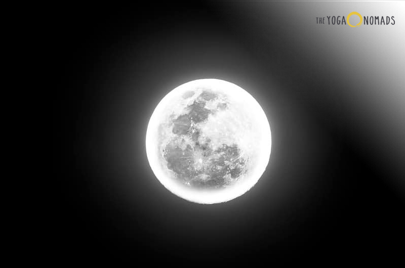 Is yin good or bad? The image features a full moon centered against a dark background. The moon is detailed, showing various shades and craters on its surface, making it a focal point against the stark contrast of the surrounding darkness.