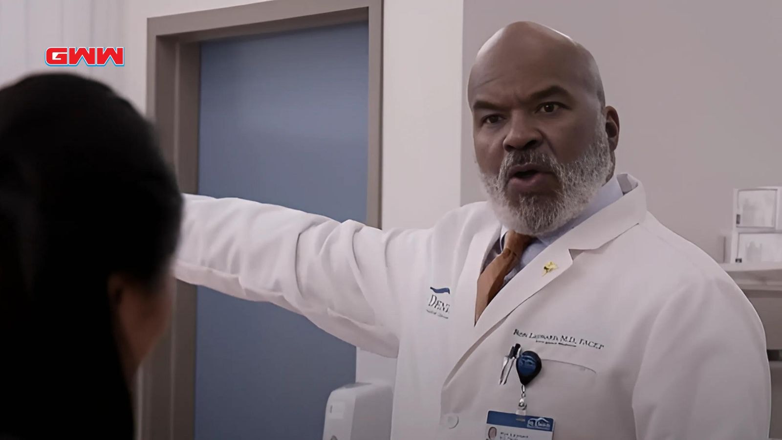 Dr. Ron Leaman gestures while speaking in hospital corridor