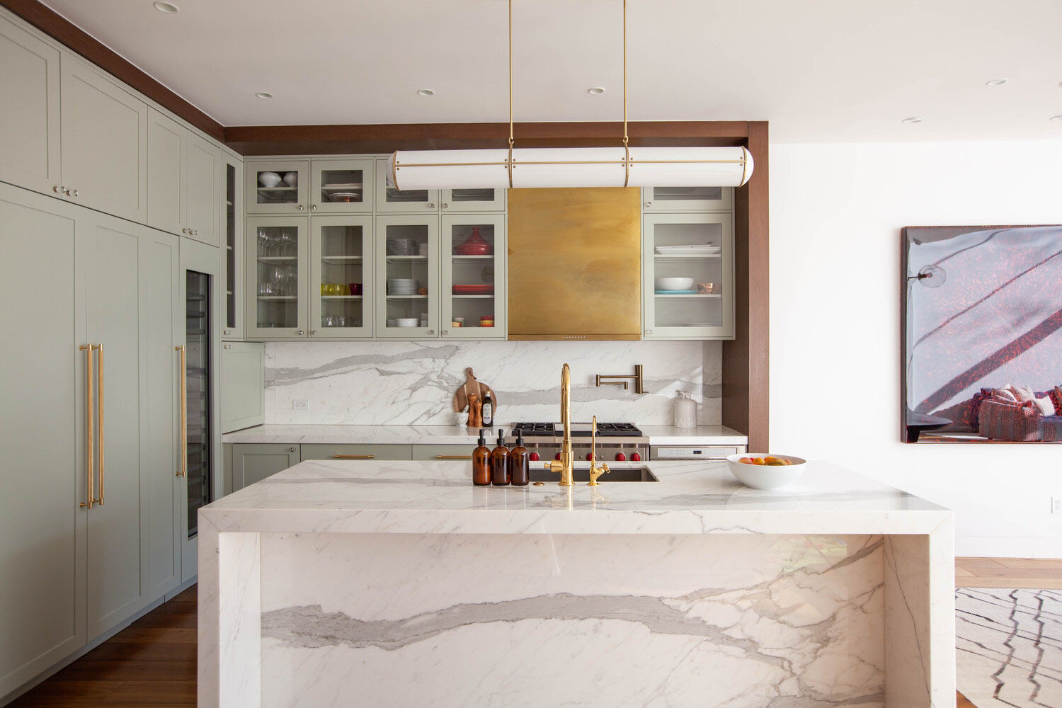 Luxuriously styled kitchen renovation with marble countertops and gold accents.