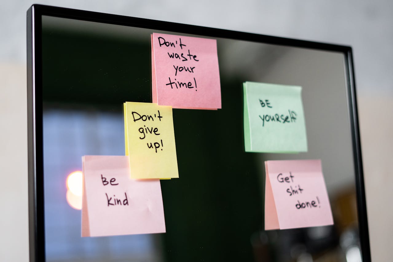 Inspirational sticky notes on a monitor reminding team members to stay motivated and focused