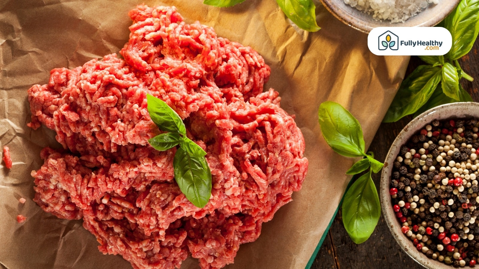 Fresh raw ground beef with herbs and whole peppercorns on paper