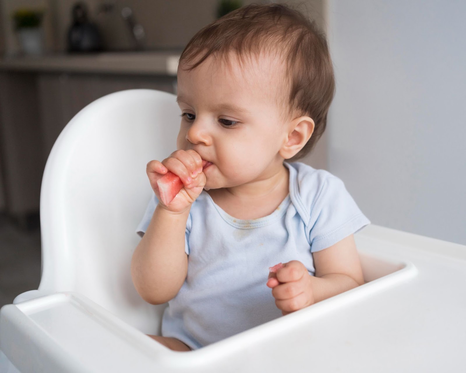 A baby eating a piece of watermelon