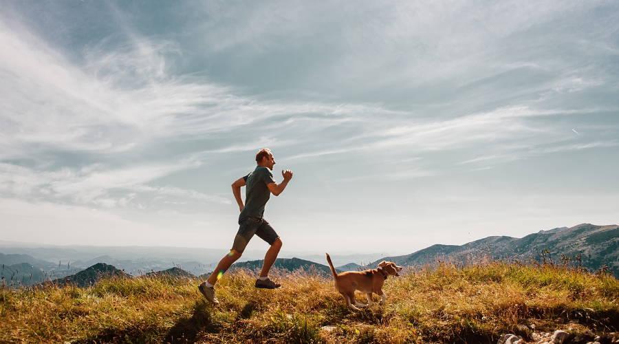 A person running with a dog

Description automatically generated