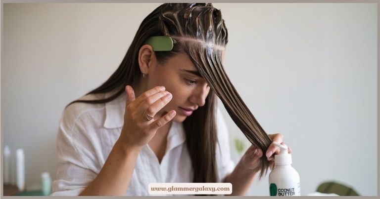 Person applying coconut butter mask to hair, holding bottle