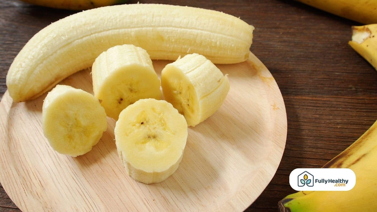 Sliced fresh banana pieces on a wooden plate for feeding