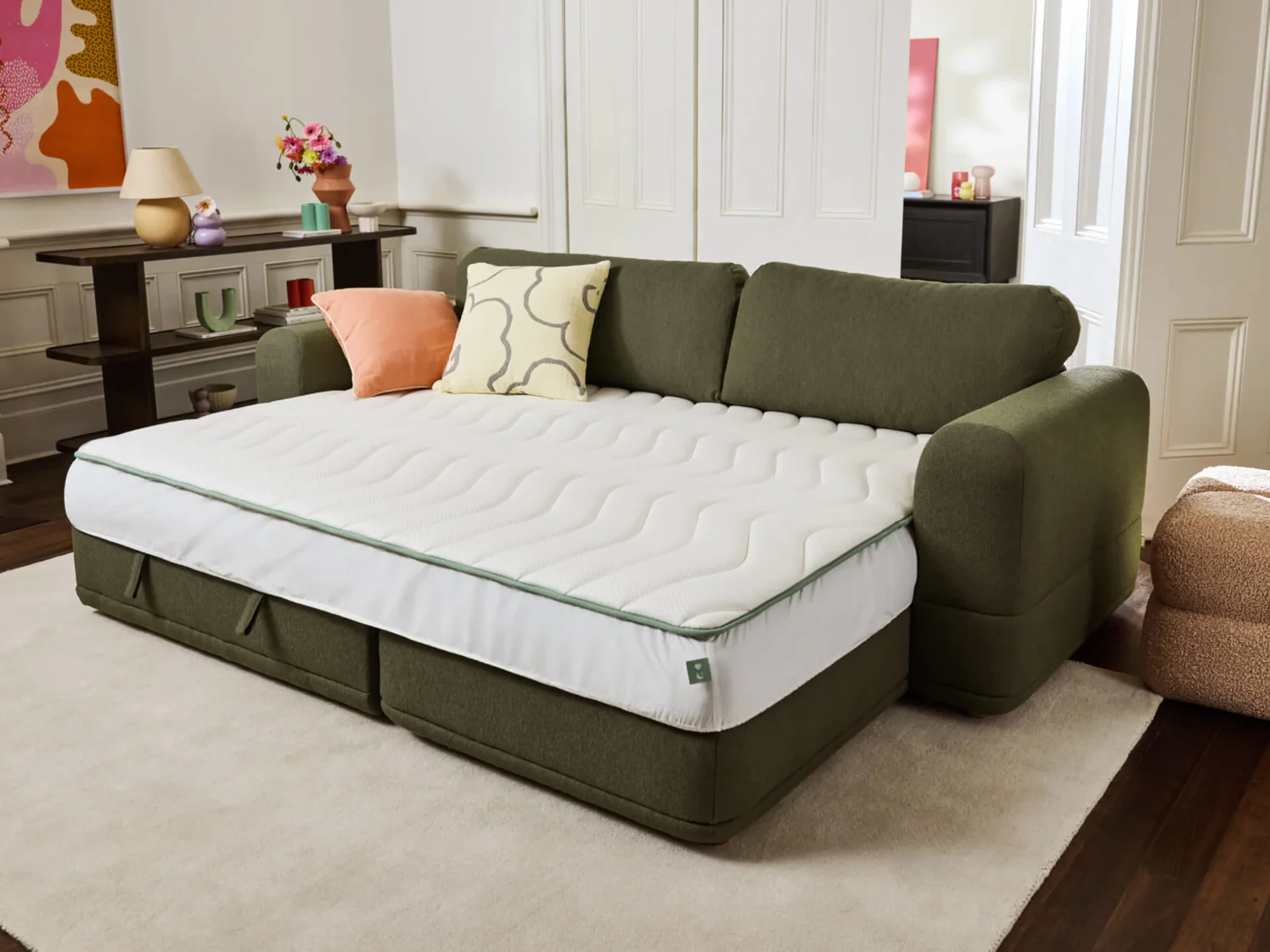 green sofa bed with a clean setup and colourful pillows