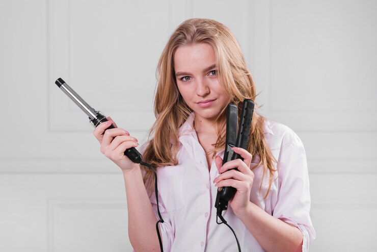 Blonde Girl holding hair styling tools