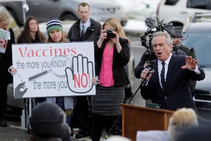 A person speaking at a podium with a sign

Description automatically generated