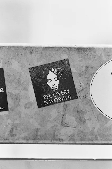 black and white photo of magnet on fridge saying recover is worth it