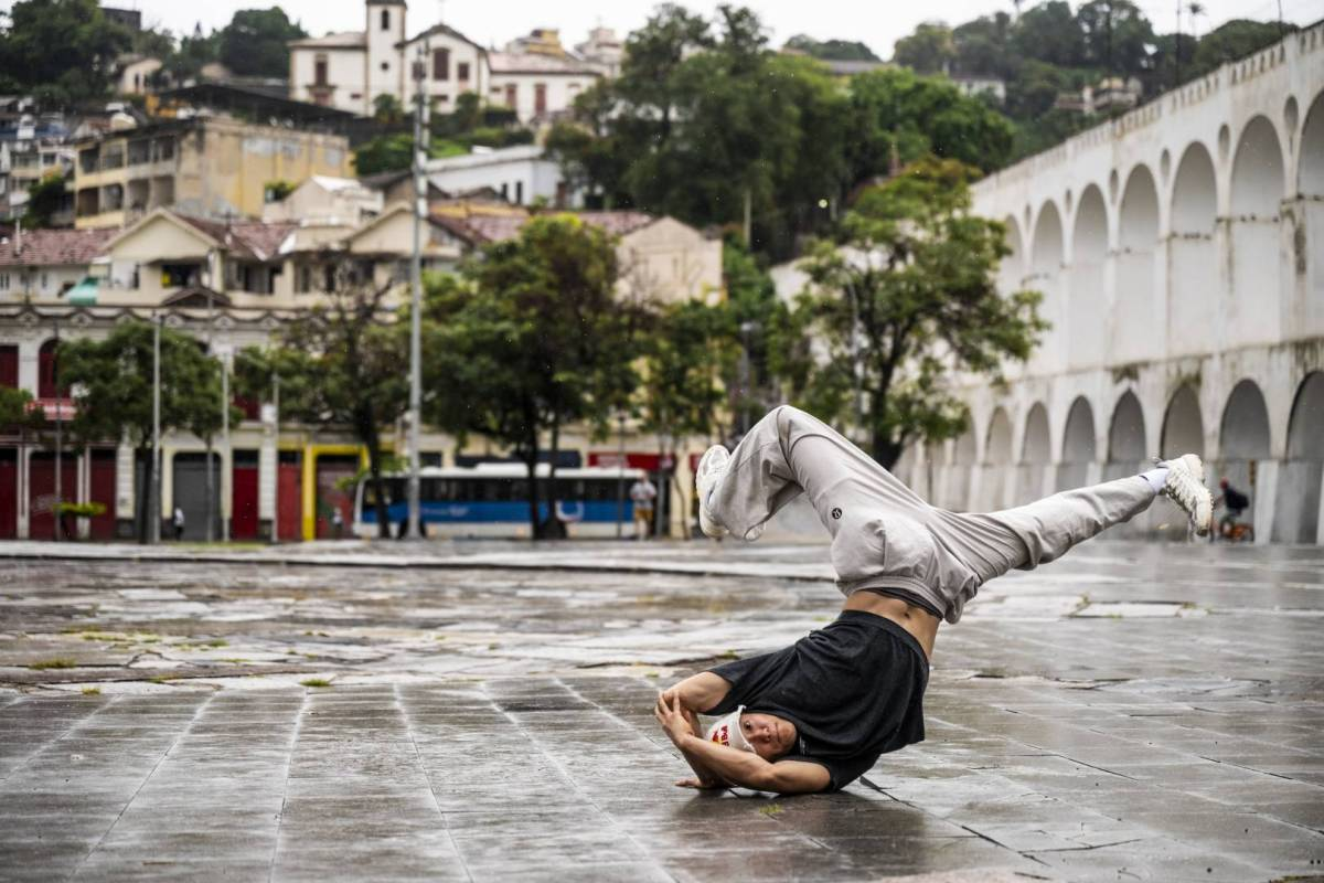 Phil Wzard breaks on a rainy street in fot f soe bauiful mediterranean-looking architecture