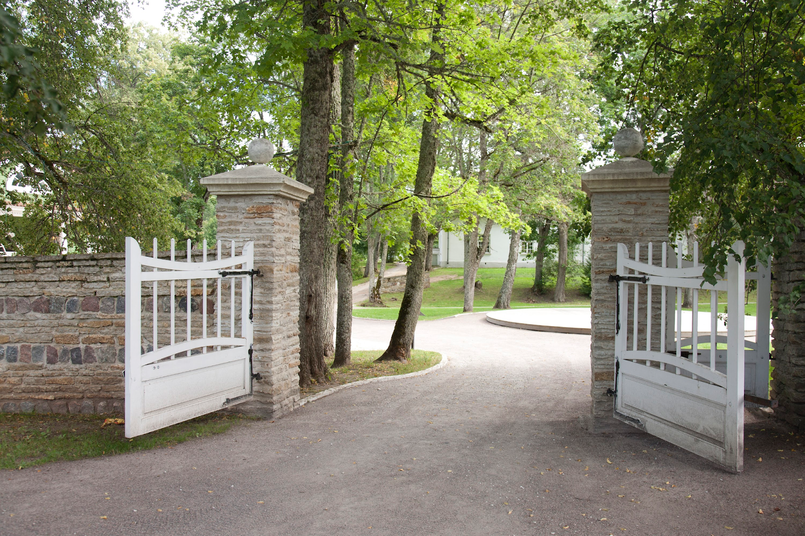 A white wooden outdoor gate that’s open.